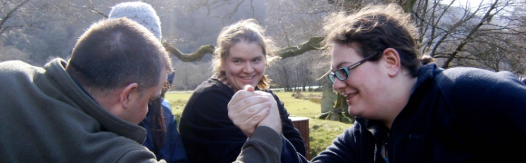 Student and professor arm wrestle  in Northern Ireland. 